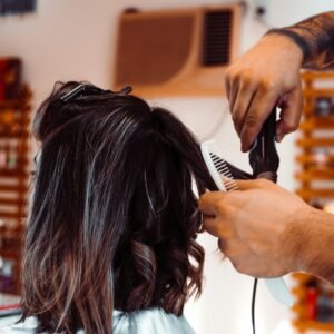 woman in white shirt holding hair blower